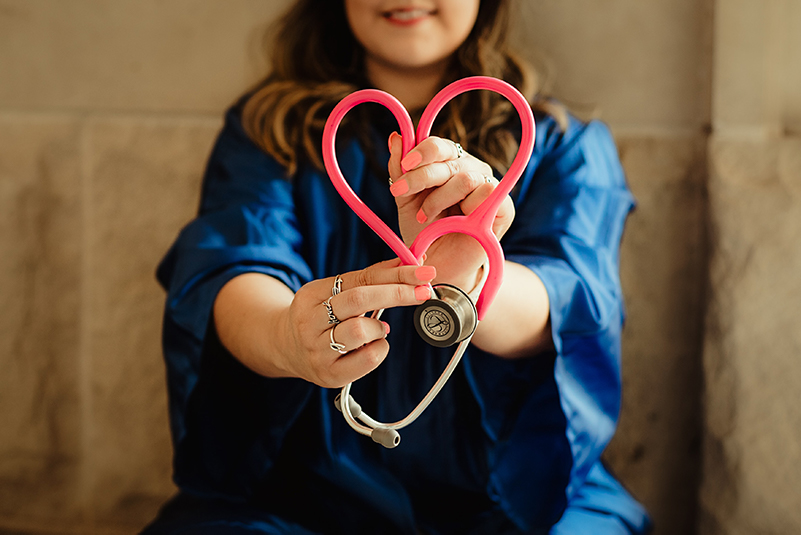Nurse holding a pink heart-shaped stethoscope